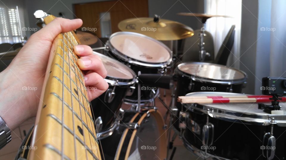 playing electric guitar with drum in the background