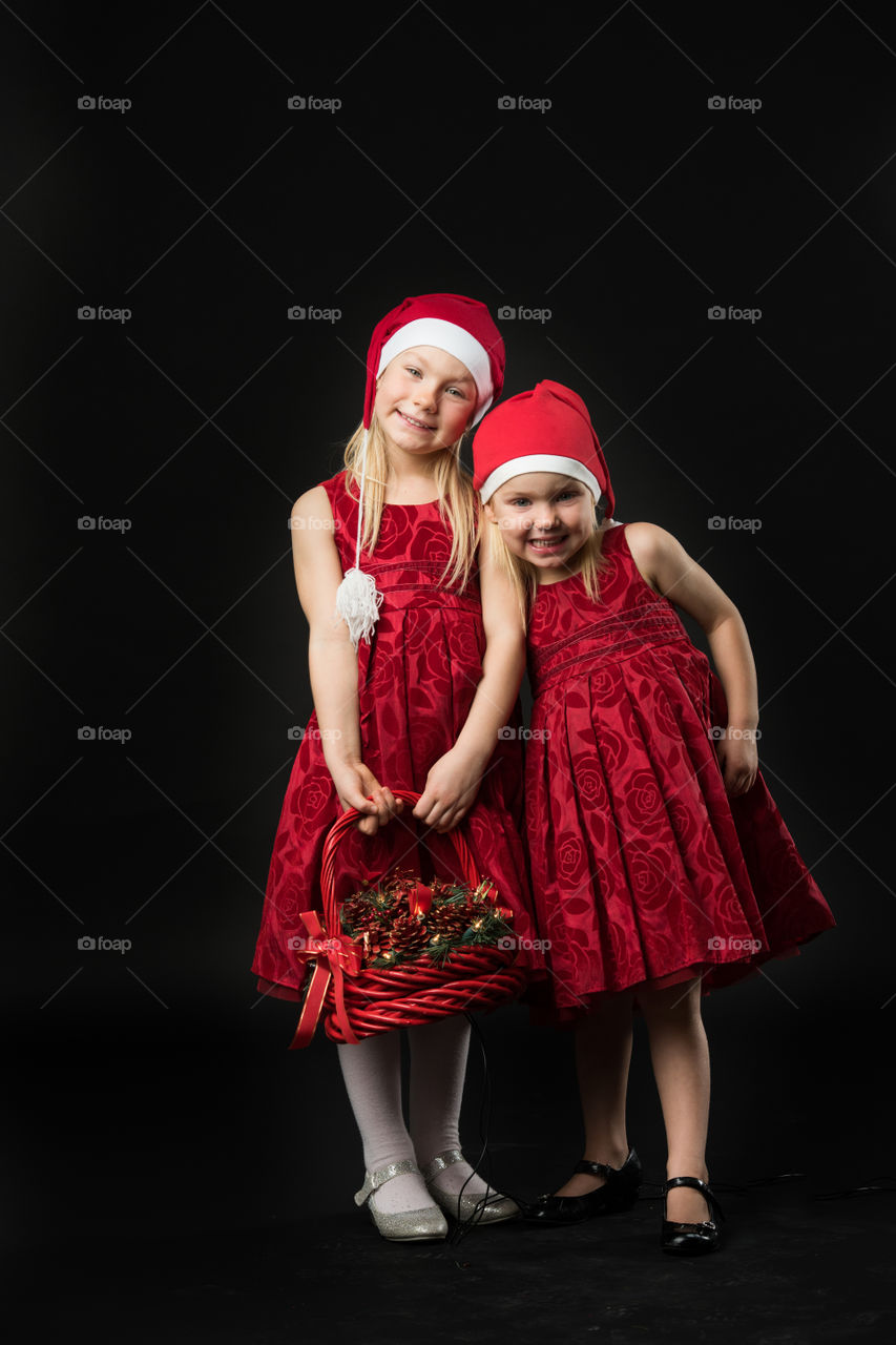 Two sisters posing for christmas portrait.