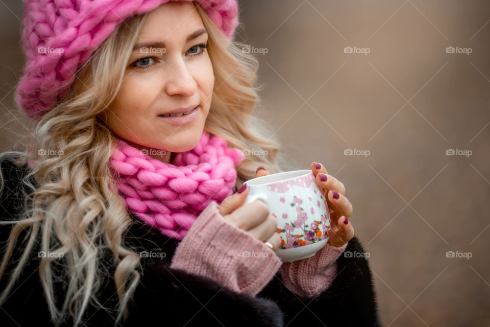 Outdoor Portrait of blonde woman in pink crochet accessories 