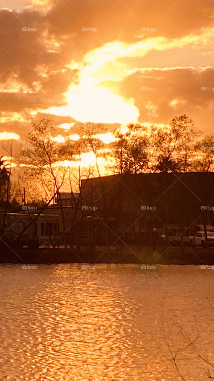 Evening sunset Reflective silhouette on Lake Water with Evening Colors timing for Sunset. Mostly Cloudy Heavy Clouds building for Strong Weather Front Headed to this Region.