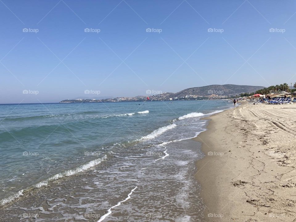 Beach time on holidays. Blue sky and tall palm trees. Sunsets and sunny days. Summertime in Kusadasi. Vacation travel in Turkey . Summer view. Sunny day during vacation 