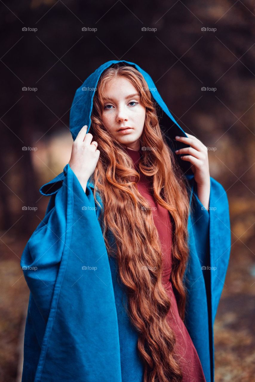 Young woman in blue coat with long red hair