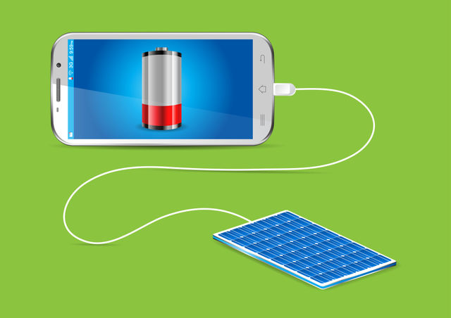 Charging mobile phone with a solar charger  -  concept image
