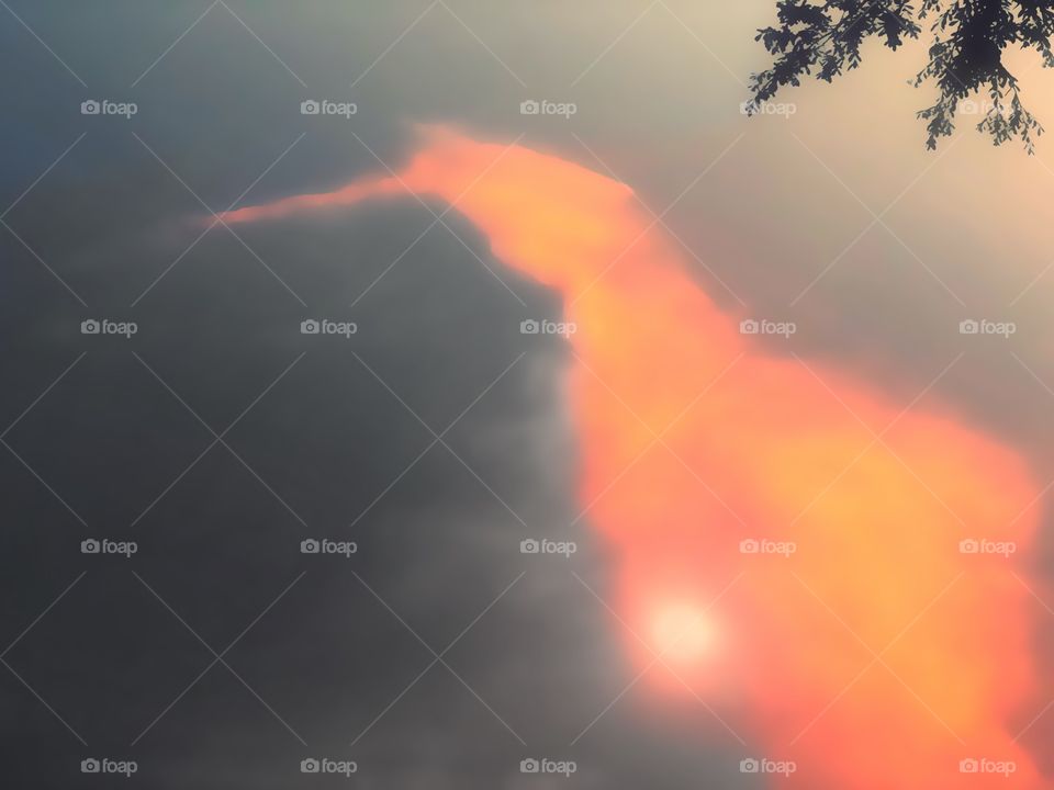 Unique sunset , the sun glowing brightly in a strange orange cloud.