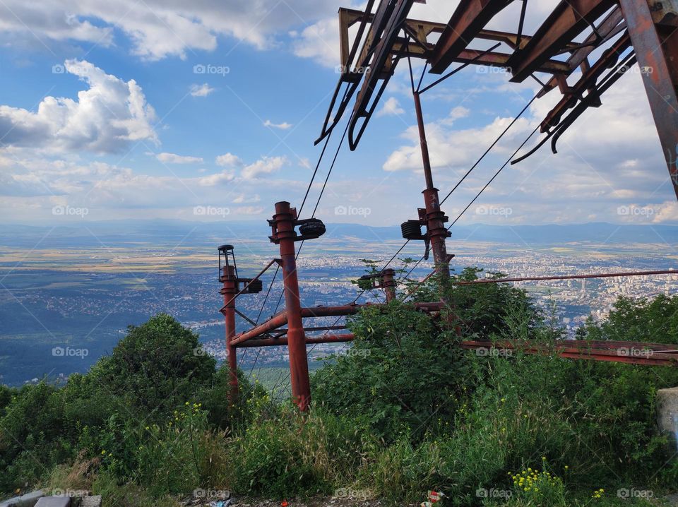 A beautiful view of the capital city of Bulgaria from Vitosha mountain with an abandoned old ski lift construction and green nature