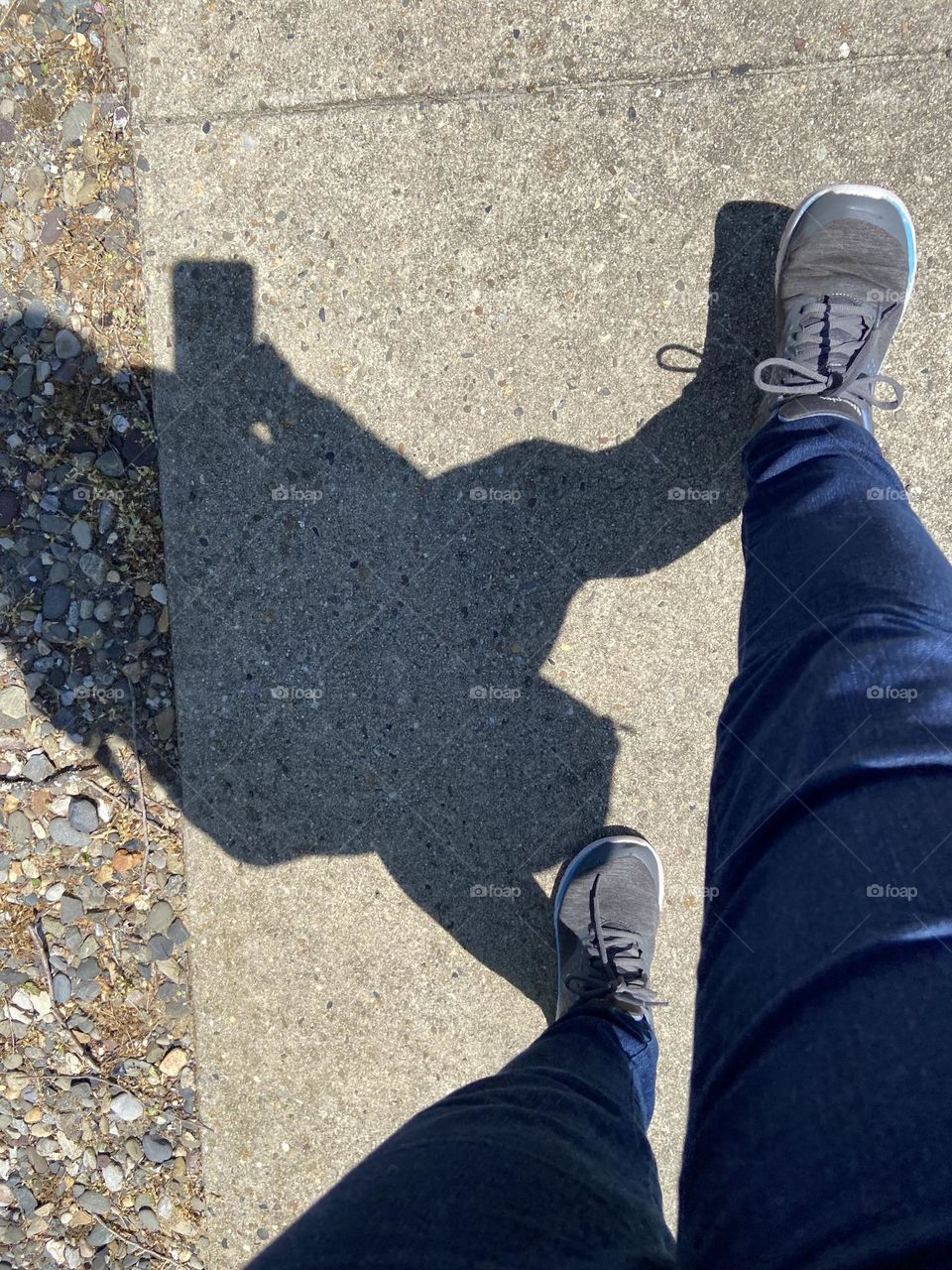 Out for my almost daily walk while on my cell phone, fielding a call from work while sneaking in some exercise. My shadow and my phone’s shadow are on the sidewalk.