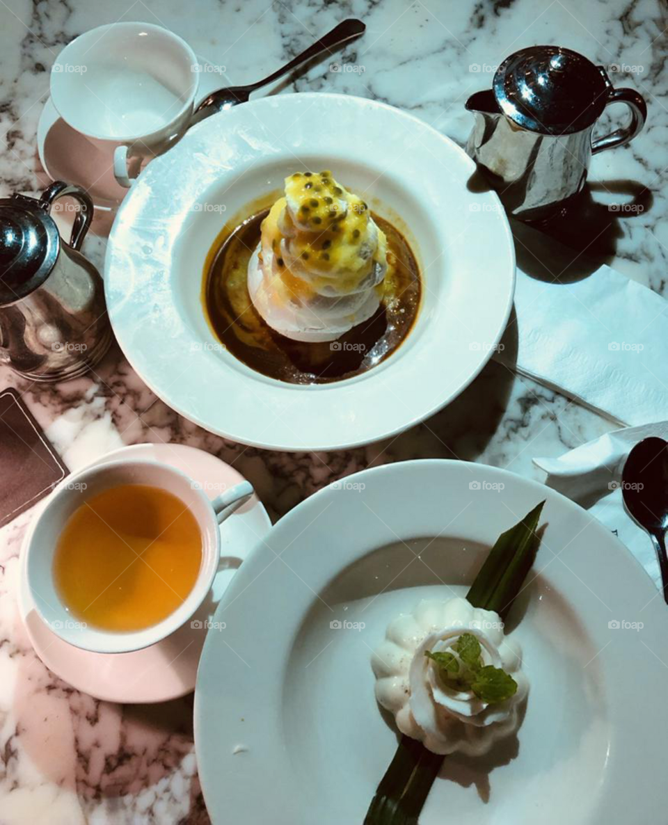 Tea time set up from above, desserts and cakes with cup of tea from above, food flat lay, food from above, dessert time against marble surface