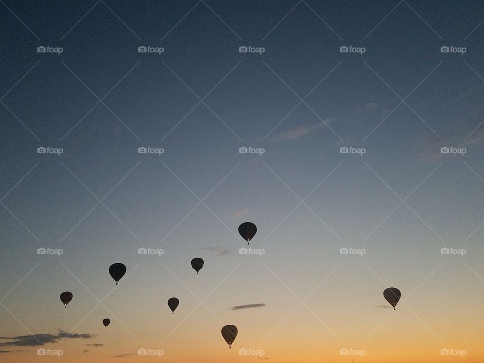 Dark silhouettes of hot air balloons at dawn
