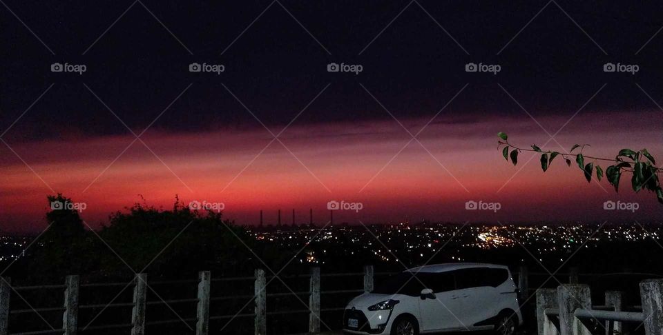 Best of the best: under a road lamp, looked the landscape of distant city lights and beautiful sky from hill at dusk.