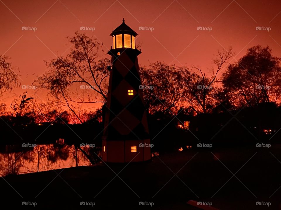Majestic Lighthouse reflections from inside light globe from Beautiful perfect Backlit Orange Glow of the Twilight very near to Captivating this Sunset soon to be Night.