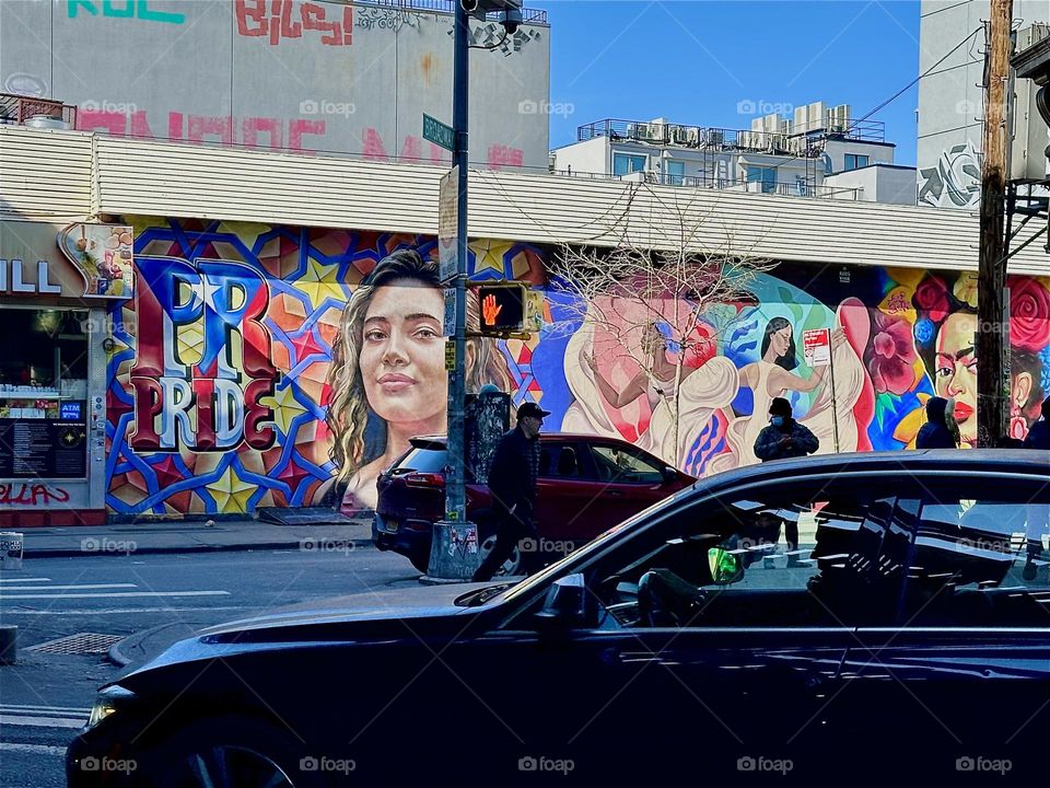 This beautiful art mural on „Jefferson St“ and „Broadway“ in „Bushwick“, Brooklyn shows a young hispanic woman next to the word „PRIDE“, a dancer in a white dress and a mulatto lady. 2024. Hypnotic Productions