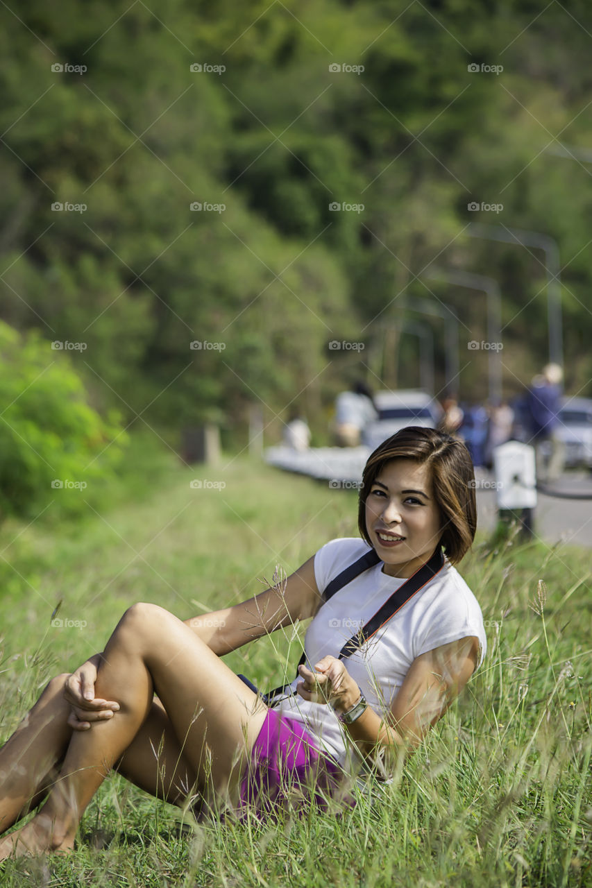 Portrait of Women with short hair brown skin Sitting on the grass.