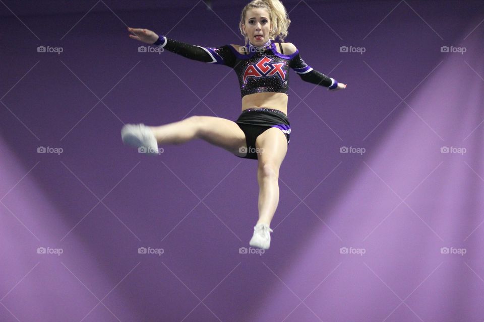 Female sportsperson jumping on purple background