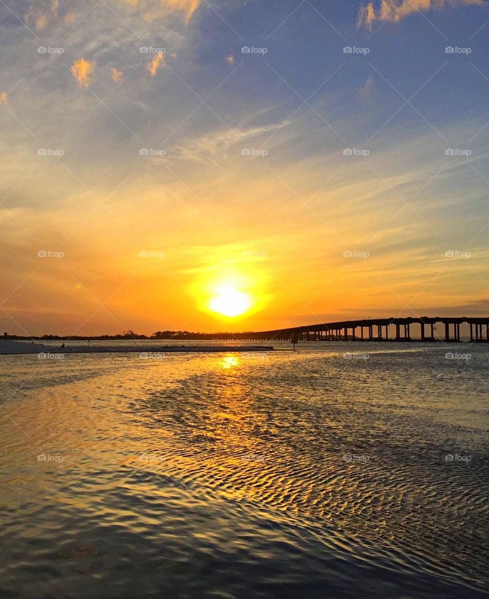 The sky was a light shade of blue which gradually spread into a mesh of poppy white, 
gold and yellow. The clouds were like thin sheets of smooth cotton in the sky; not there to bring in the storm, but to add color to my sunset. 