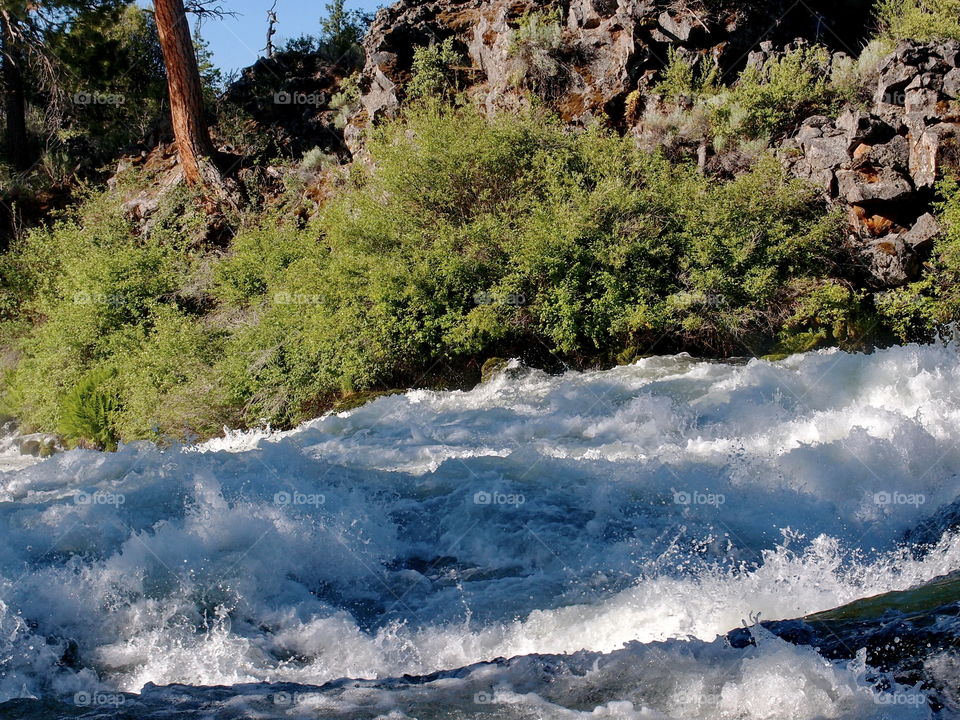 The raging waters of the Deschutes River at Dillon Falls on a sunny summer day 