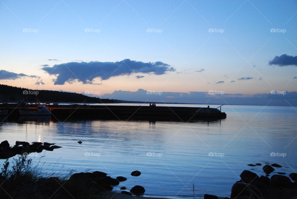 Silhouette of pier in lake during sunset