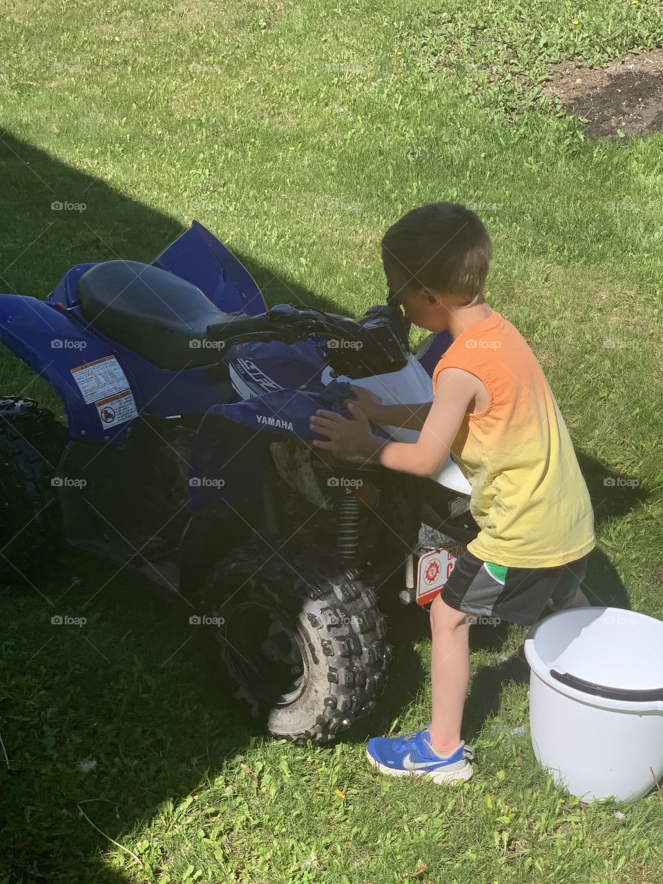 Boy cleaning is ATV 