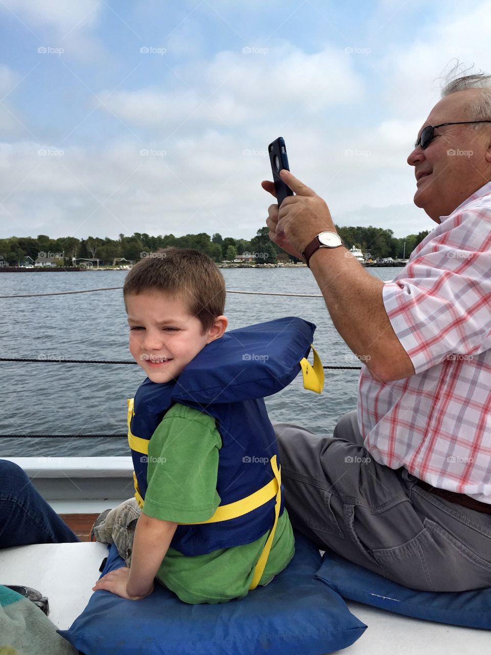 Grandson and grandfather sitting in boat