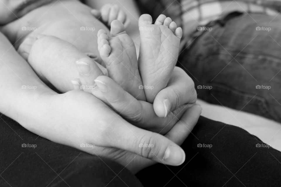 Close-up of mother's hand holding babies foot