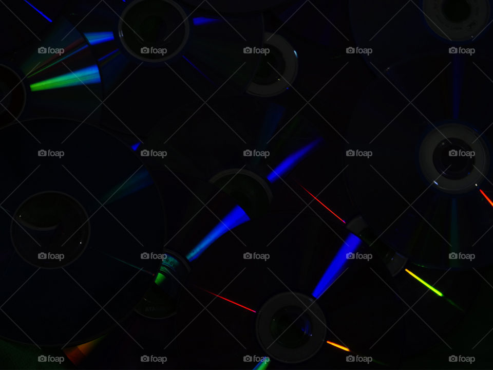 CDs iluminados emanando distintos rayos de colores