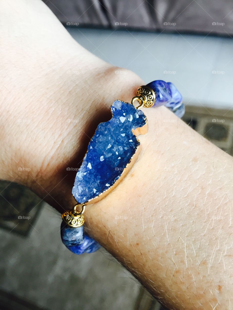 This is a blue agate druzy arrowhead connector with blue agate oblong beads, and gold tone finishing beads meant to compliment the gold wrapping on the druzy.