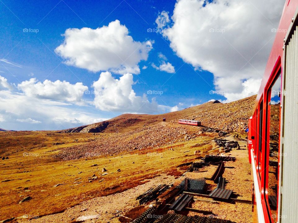 Red trains on the side of a mountain, above the treeline in Pike National Forest, Colorado. 
