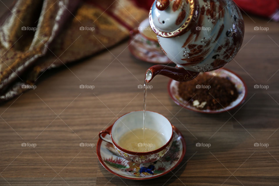 Close-up of pouring tea in the cup