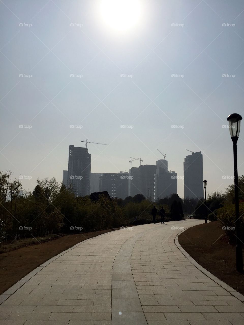 A walkway through park to the city