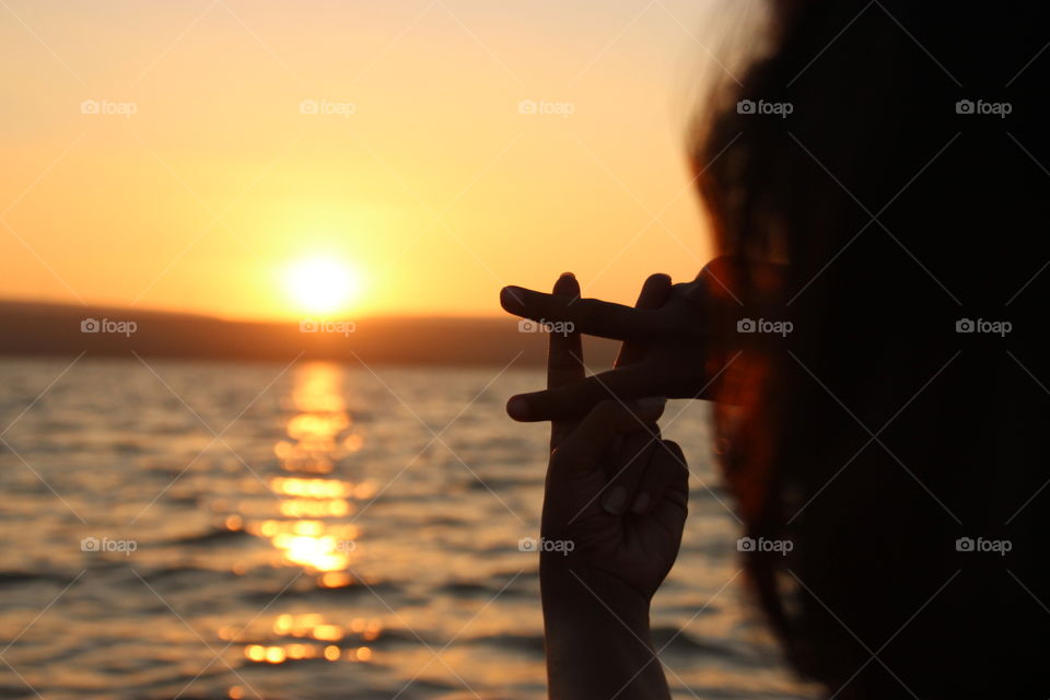 Hand signs as capturing sunset, women hand sign