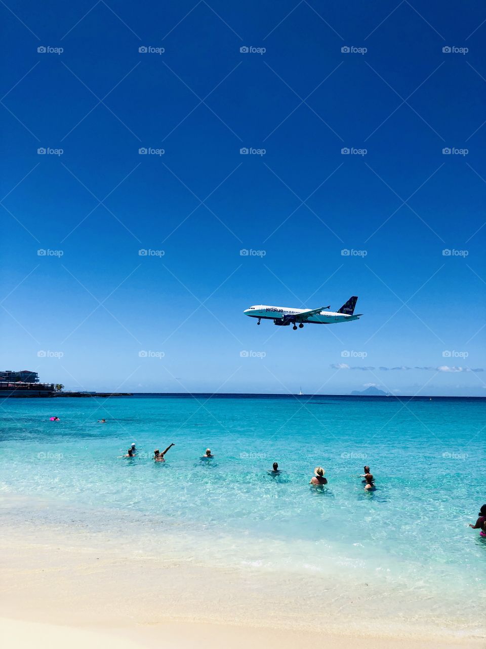 Airplane flying over swimmers on the beach in St Marteen - JetBlue - Editorial 