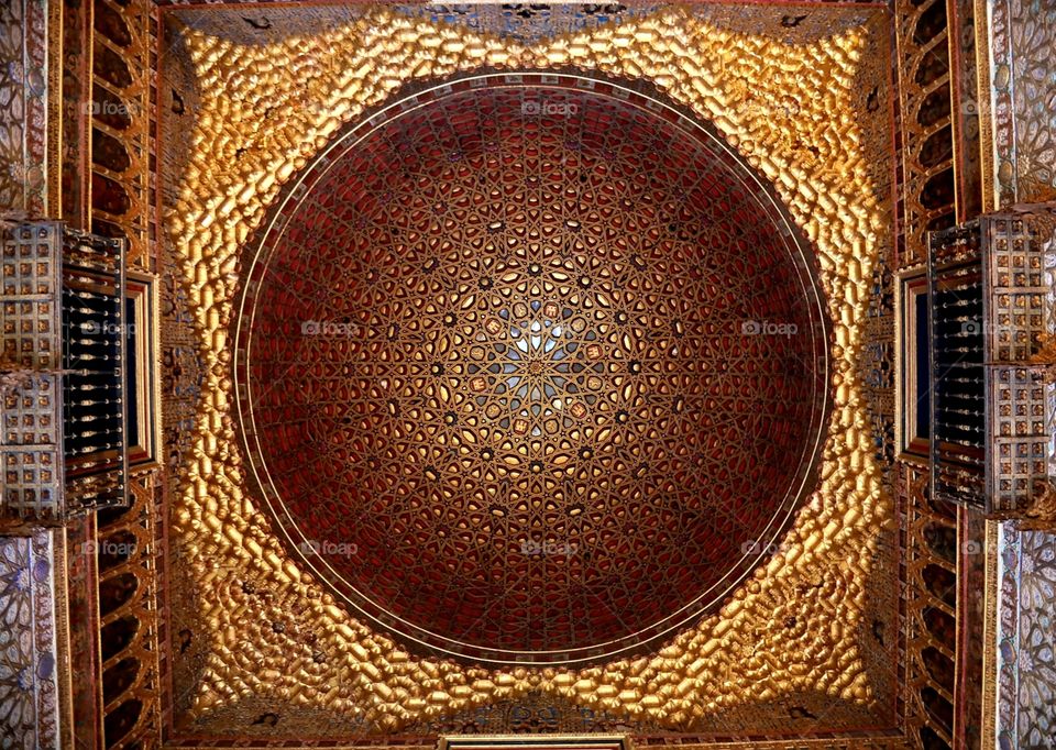 Richly decorated ceiling in the Alcazar palace in Seville, Spain