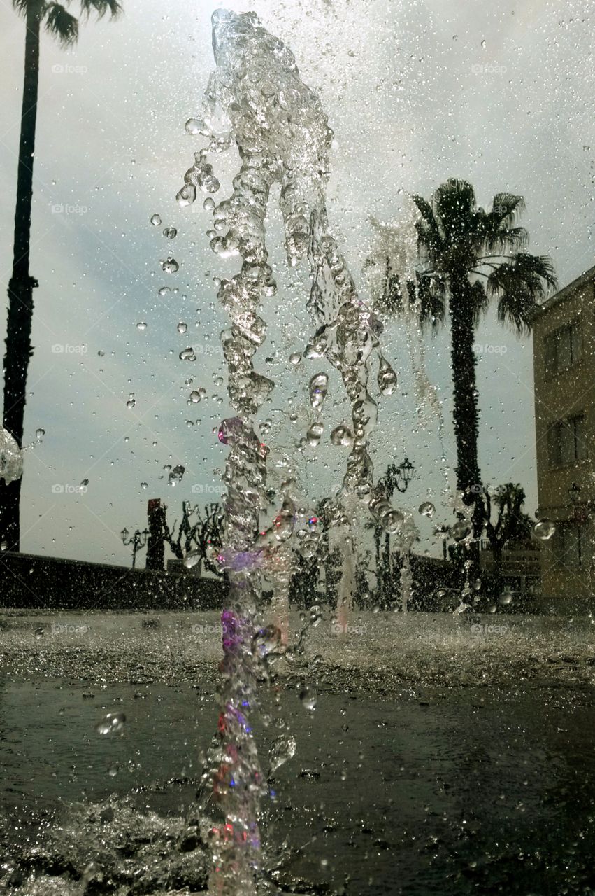 water in motion: Close up of water splash from a fountain with colored light