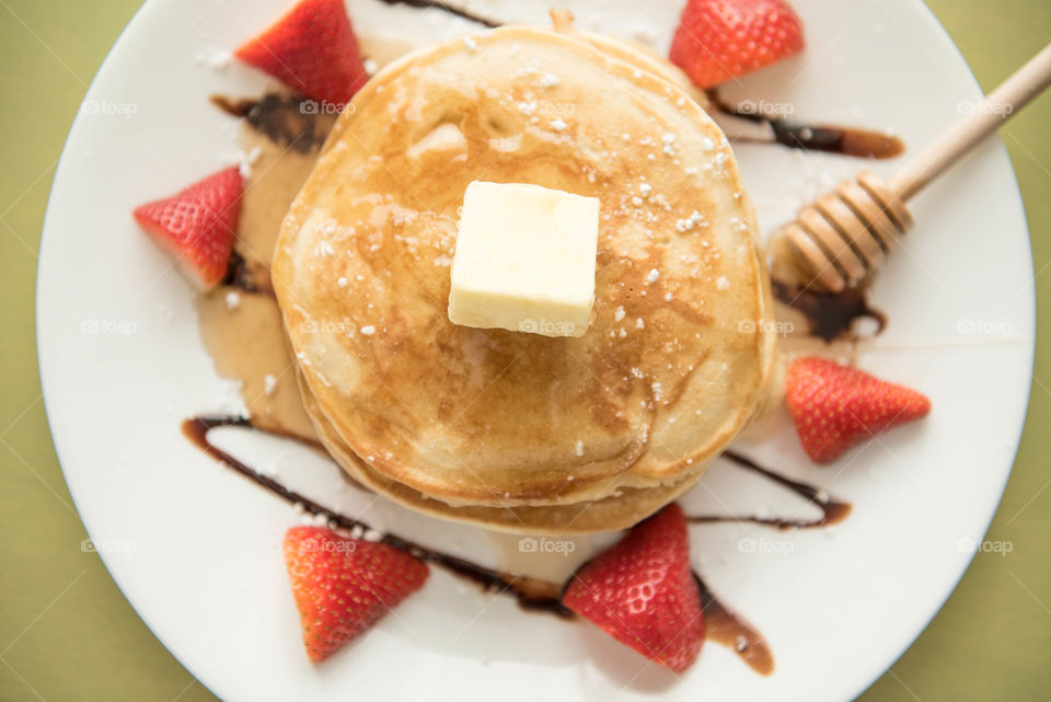 Top view close-up of a stack of pancakes with butter