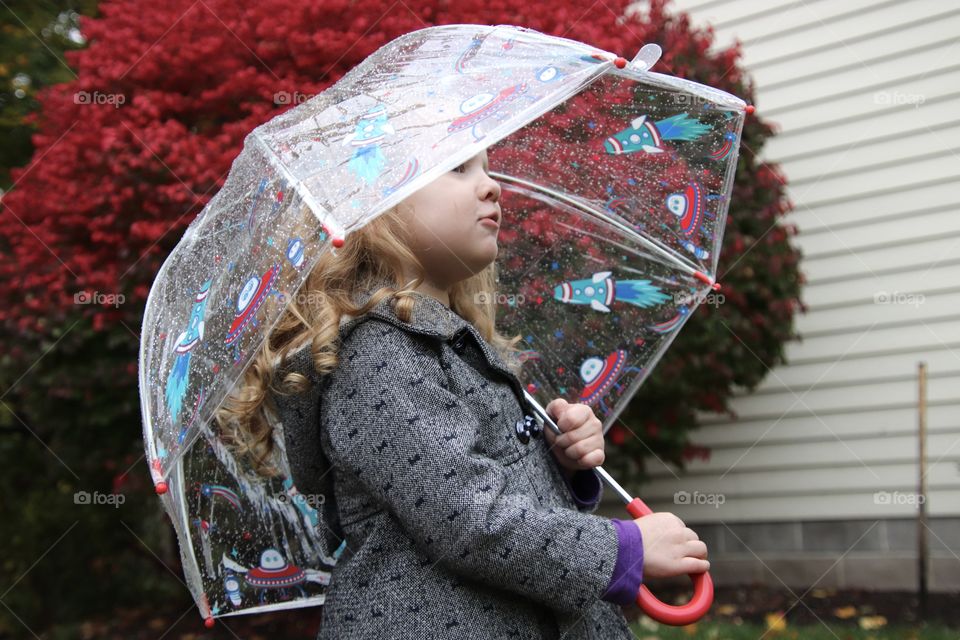 Girl holding umbrella on rainy day 