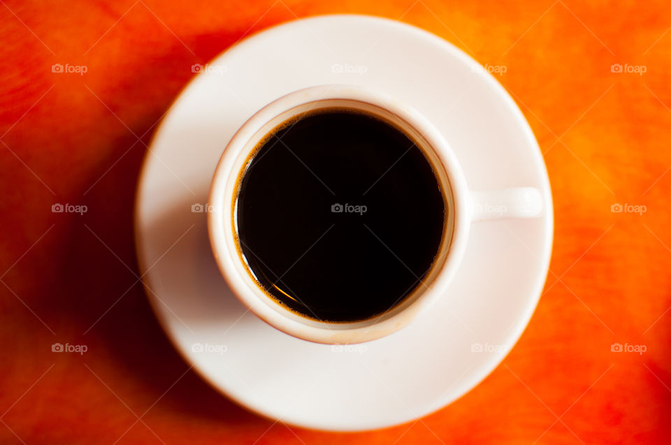 White espresso cup over orange table 