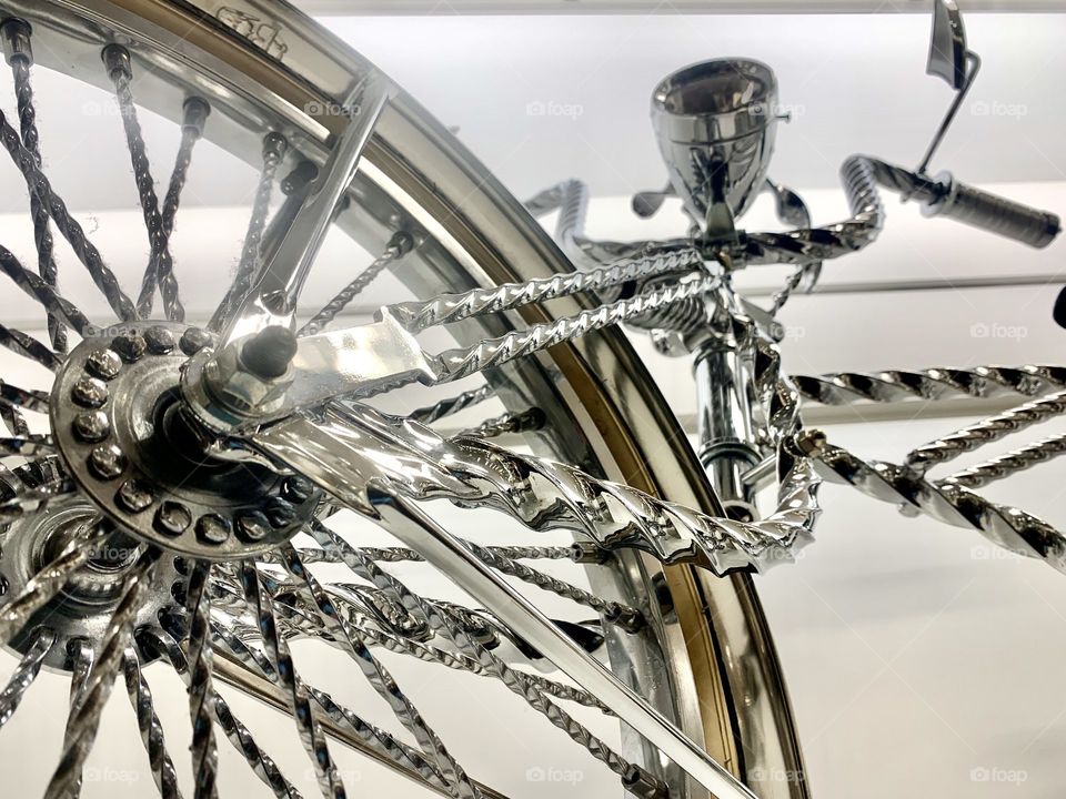 Chrome bicycle close up looking at spokes and chrome handlebars