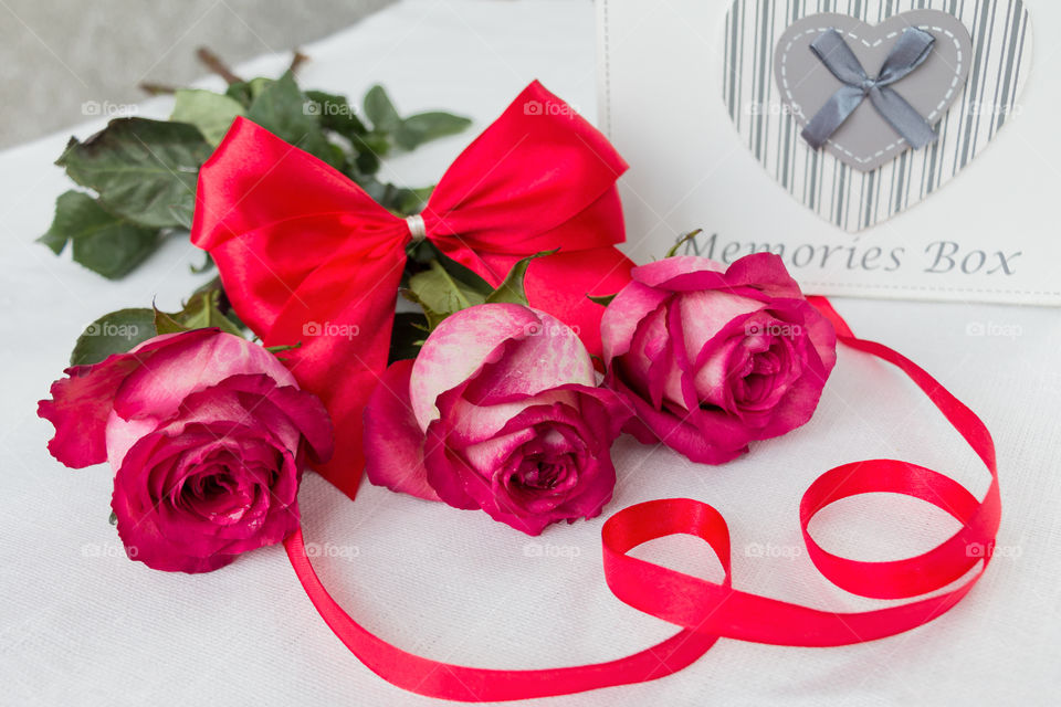 a bouquet of red roses and red bow