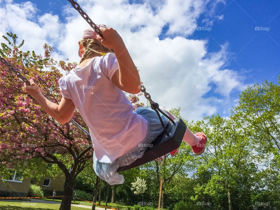 Young girl swinging on a playground in Malmö Sweden.