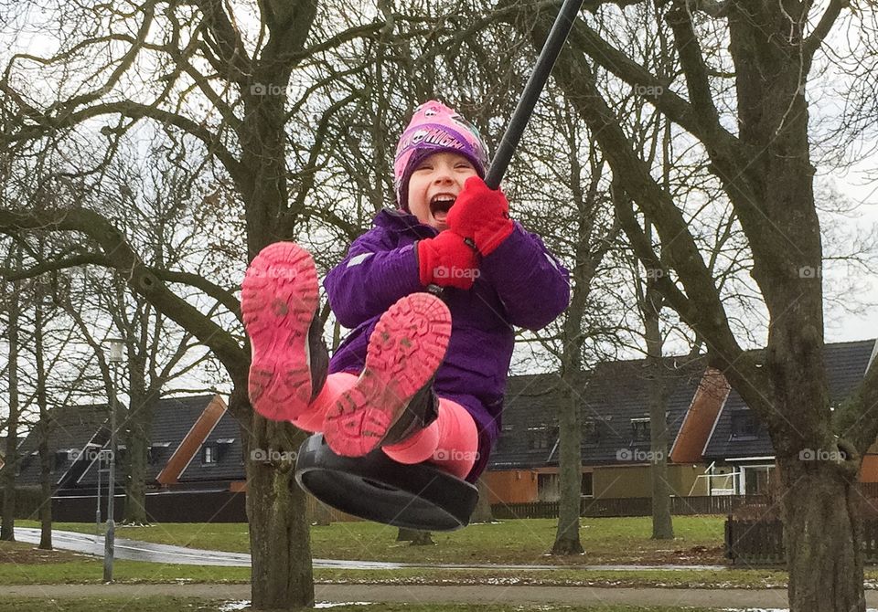 little girl of five years rides the cable car at a playground.