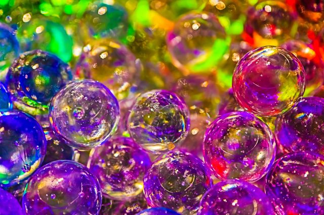 Colorful shiny glass marbles reflecting a rainbow of colors, closeup macro image 