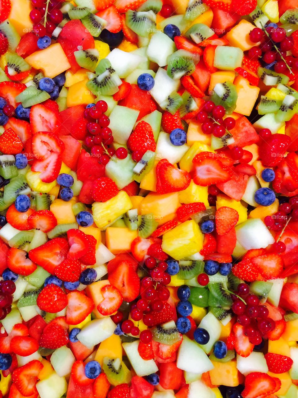 A very berry fruitsalad with melon, apple, blueberry, redberry, strawberry and pineapple, kiwi 