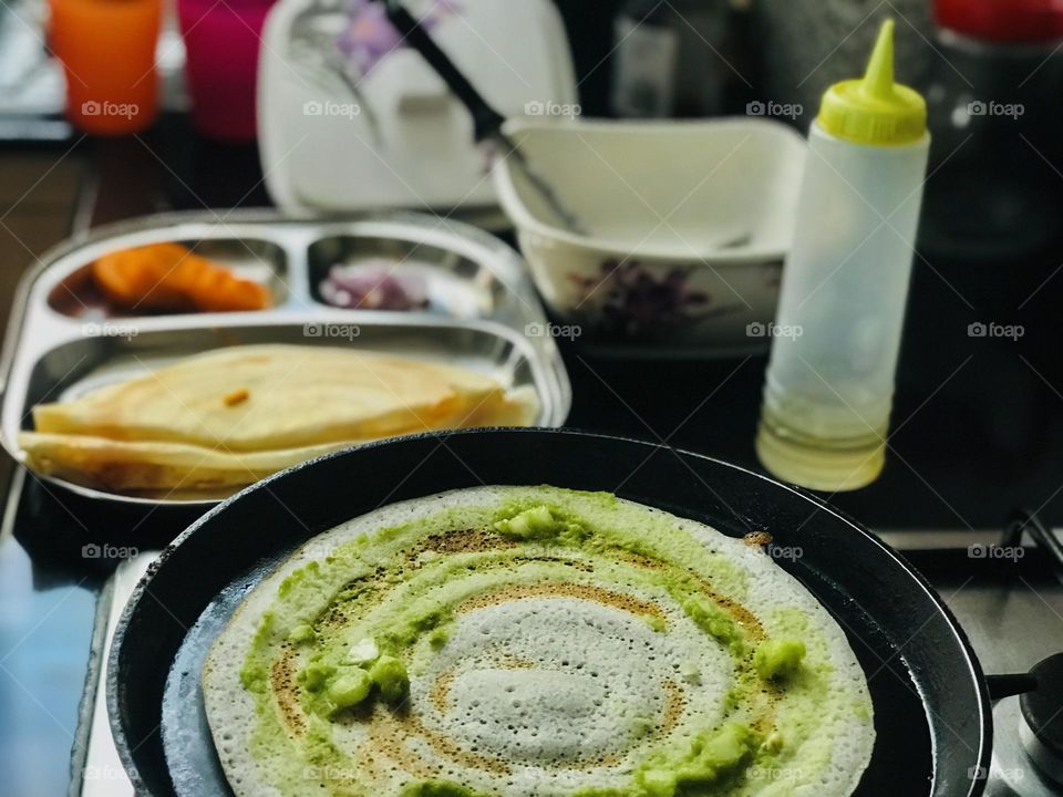 Preparing dosa on pan 