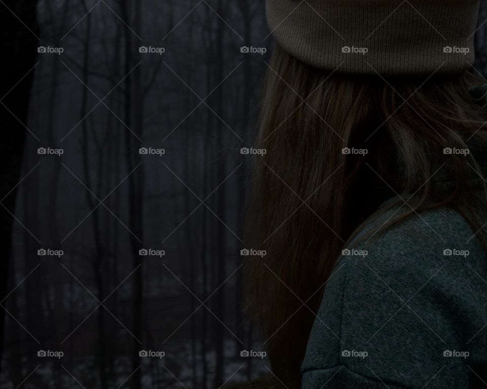 Woman looking out over a foggy, winter forest