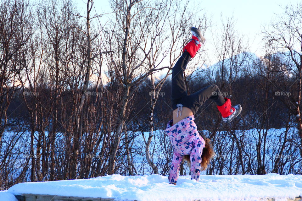 Little girl doing handstand in winter