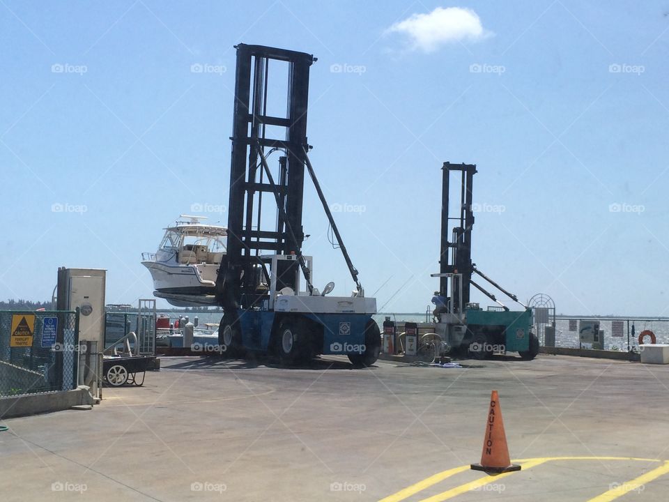 Boat being lifted out of the water to be put in dry storage at a marina in Florida.