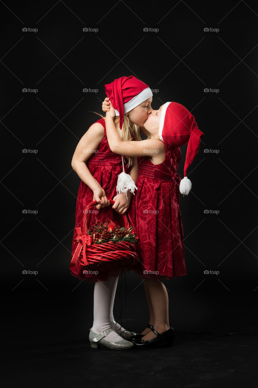 Two sisters posing for christmas portrait.