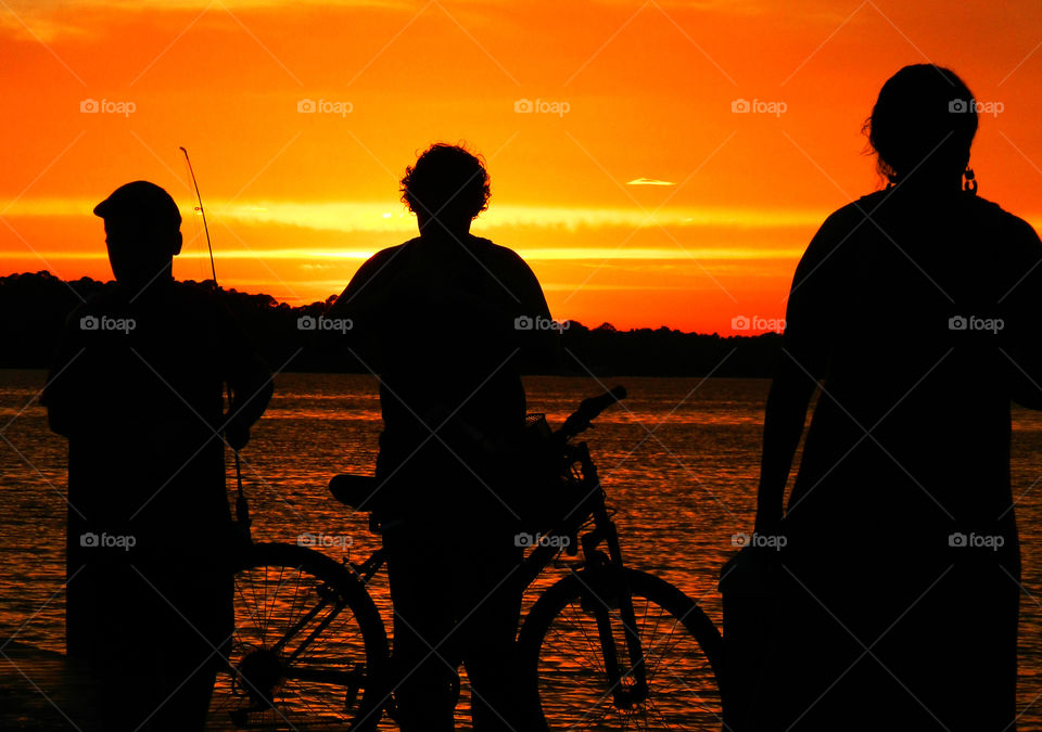 View the sunset from my bike. Viewing the sunset from my bike while watching a fisherman troll for fish. 