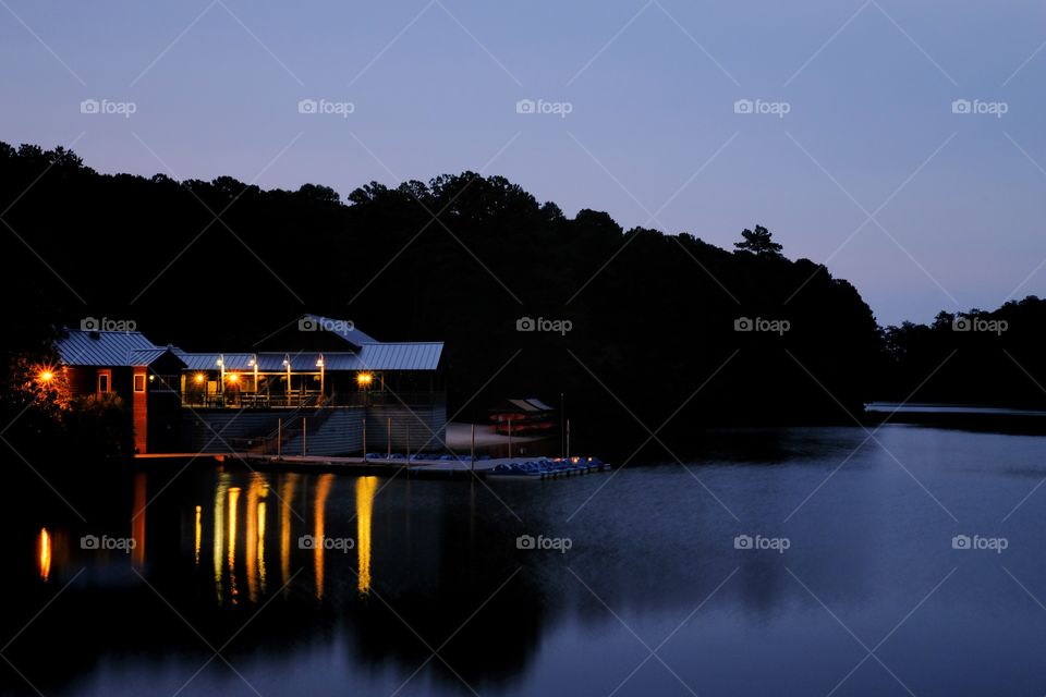 Foap, Light: Natural vs Artificial - the lights from a boathouse cast vivid reflections in the water at Lake Johnson Park in Raleigh, North Carolina. 