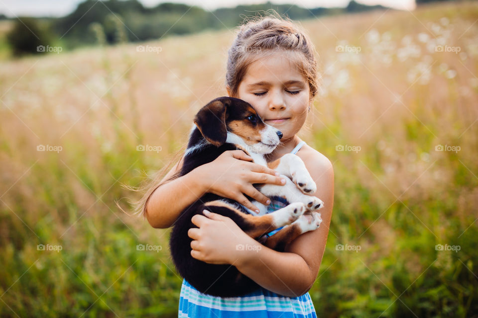 Child holding a puppy 