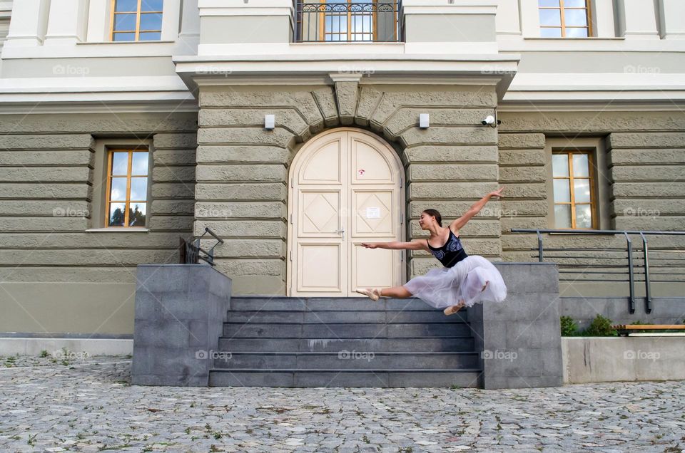 Beautiful Young Girl Ballerina jumping on the street